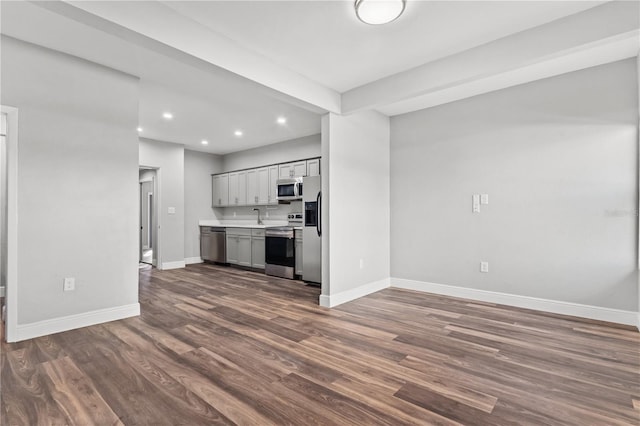 unfurnished living room with sink and hardwood / wood-style floors