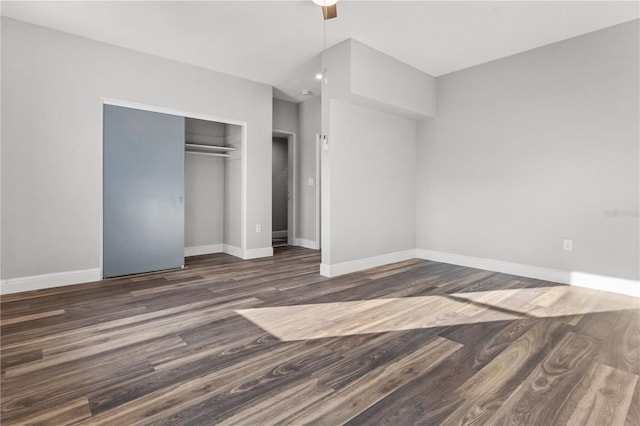 unfurnished bedroom featuring dark wood-type flooring, a closet, and ceiling fan