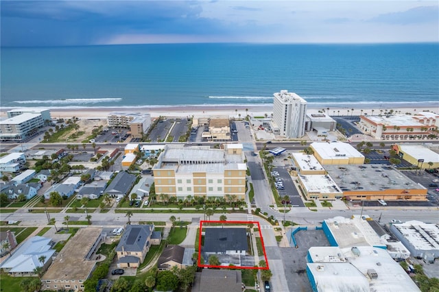 birds eye view of property featuring a water view and a beach view