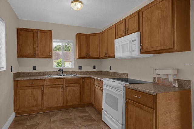 kitchen featuring light tile patterned floors, white appliances, and sink