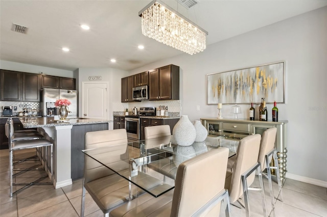 tiled dining area featuring a notable chandelier