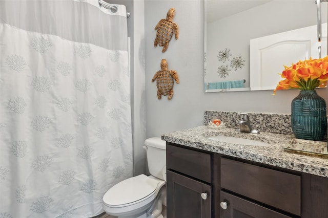 bathroom featuring vanity, toilet, and walk in shower