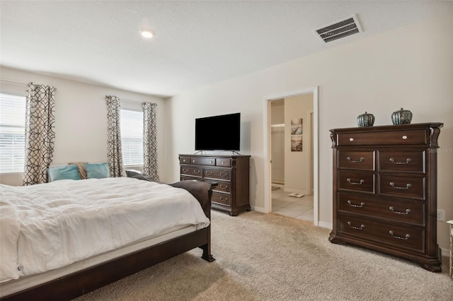 carpeted bedroom featuring ensuite bath