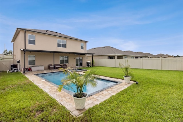 rear view of property featuring a fenced in pool, a yard, and a patio