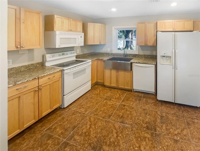 kitchen featuring dark tile patterned flooring, white appliances, sink, and light brown cabinets