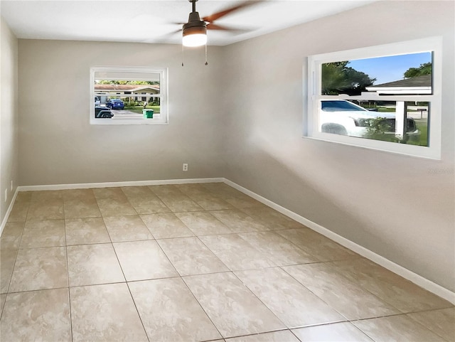 empty room featuring ceiling fan, baseboards, and light tile patterned flooring