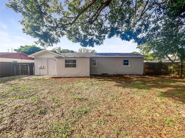 rear view of property featuring a fenced backyard