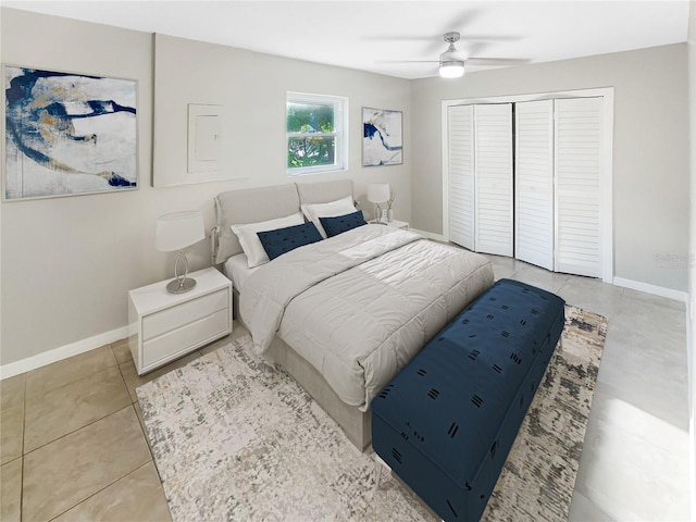 bedroom featuring light tile patterned floors, ceiling fan, and a closet