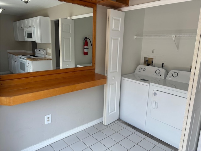 washroom featuring washing machine and clothes dryer and light tile patterned flooring