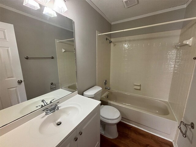 full bathroom featuring a textured ceiling, vanity, shower / tub combination, wood-type flooring, and toilet