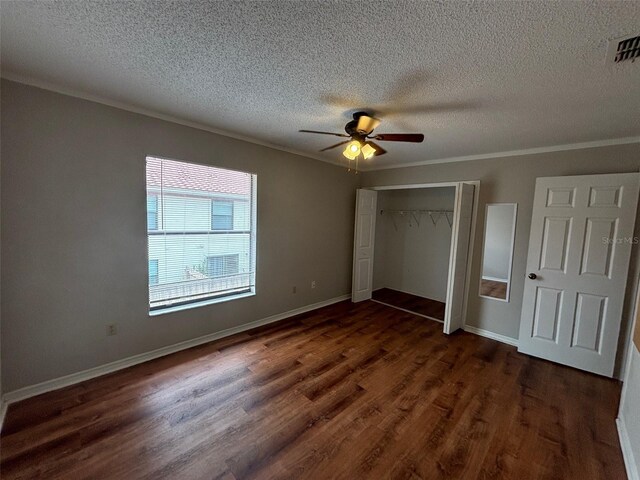 unfurnished bedroom with dark wood-type flooring, a closet, ceiling fan, and a textured ceiling