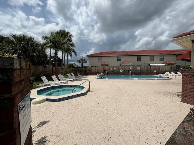 view of swimming pool with a patio and a hot tub