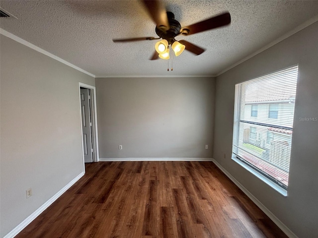 spare room featuring ceiling fan, dark hardwood / wood-style floors, crown molding, and a textured ceiling