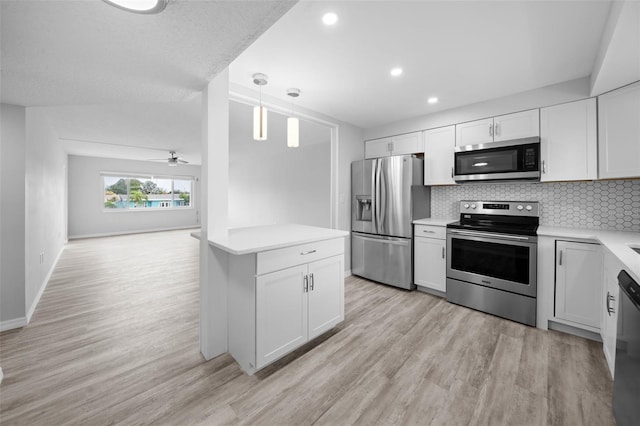 kitchen featuring decorative light fixtures, backsplash, stainless steel appliances, white cabinetry, and light wood-type flooring