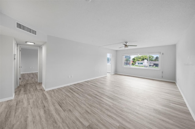 spare room with a textured ceiling, light hardwood / wood-style flooring, and ceiling fan