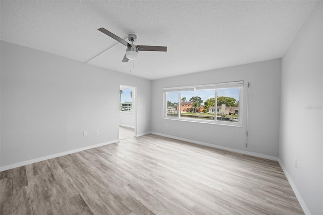 spare room featuring a textured ceiling, light hardwood / wood-style flooring, and ceiling fan