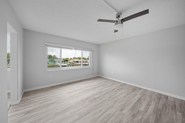 empty room featuring a textured ceiling, ceiling fan, and light hardwood / wood-style floors