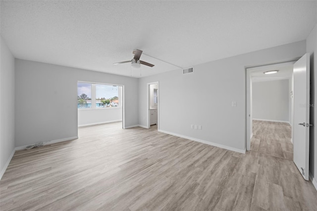 empty room with a textured ceiling, light hardwood / wood-style flooring, and ceiling fan