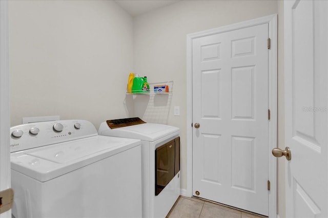 washroom featuring washing machine and dryer and light tile patterned floors