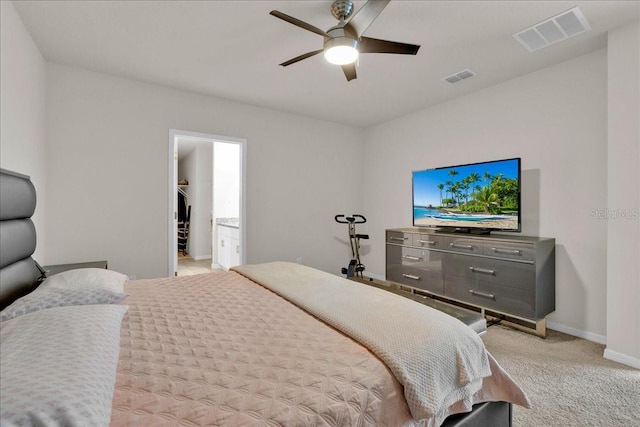 bedroom with ensuite bath, a spacious closet, ceiling fan, and carpet flooring