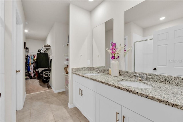 bathroom featuring tile patterned flooring, an enclosed shower, and vanity