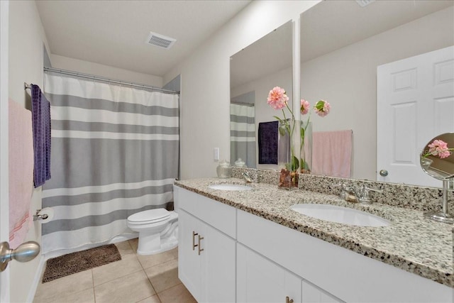 bathroom with vanity, toilet, and tile patterned flooring