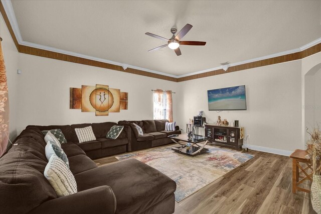 living room with ornamental molding, hardwood / wood-style floors, and ceiling fan