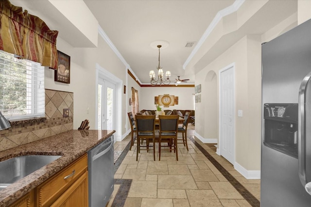 kitchen with pendant lighting, a notable chandelier, crown molding, stainless steel appliances, and decorative backsplash