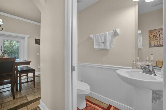 bathroom featuring ornamental molding and toilet