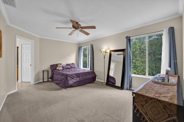 carpeted bedroom with ornamental molding and ceiling fan