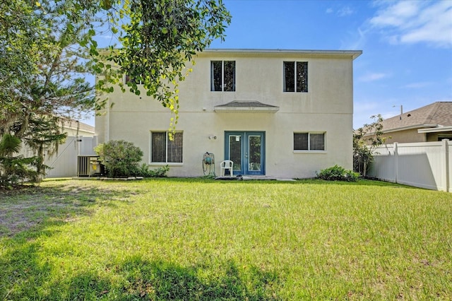 rear view of house featuring french doors and a yard