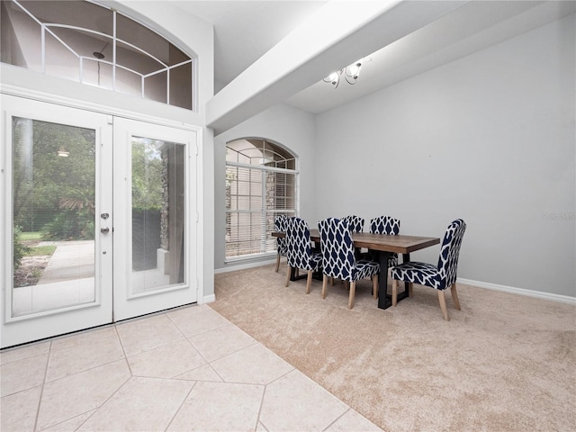 carpeted dining space featuring french doors, tile patterned flooring, and baseboards