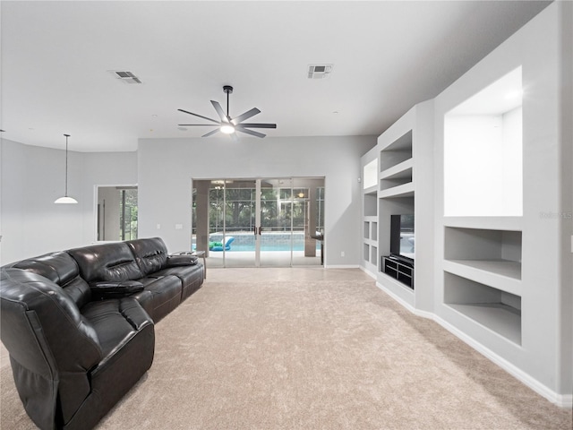 carpeted living room with built in features, visible vents, baseboards, and a ceiling fan