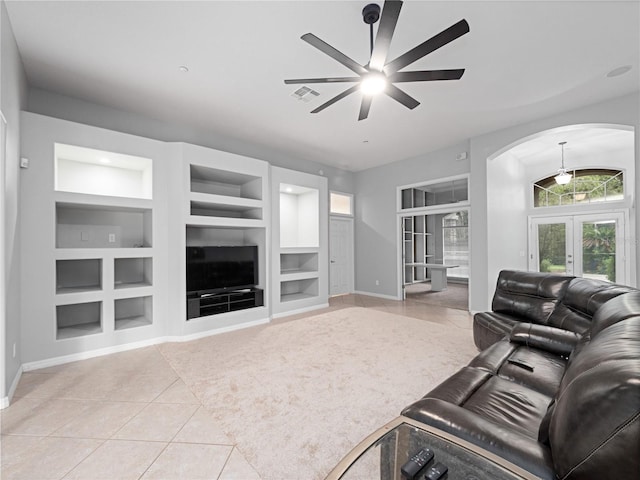 living area featuring visible vents, built in features, arched walkways, french doors, and light tile patterned flooring