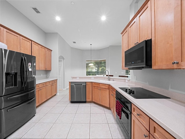 kitchen featuring visible vents, arched walkways, a peninsula, black appliances, and a sink