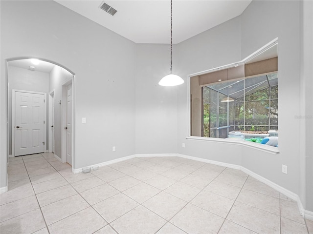 unfurnished room featuring arched walkways, a sunroom, visible vents, and tile patterned floors