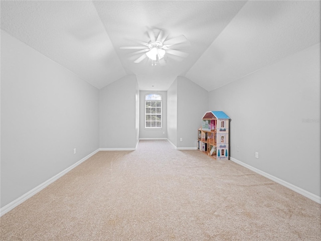 additional living space with carpet floors, vaulted ceiling, a textured ceiling, and baseboards