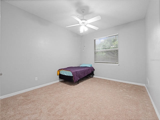 carpeted bedroom featuring a ceiling fan and baseboards