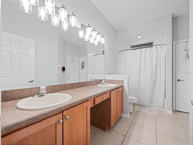 bathroom featuring double vanity, tile patterned flooring, a sink, and toilet