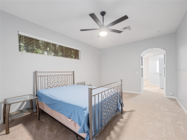 bedroom featuring arched walkways, visible vents, a ceiling fan, carpet flooring, and baseboards