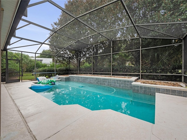 outdoor pool featuring glass enclosure and a patio area