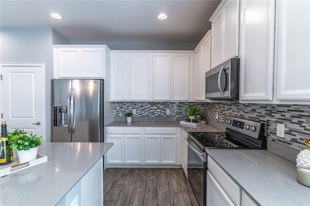 kitchen featuring backsplash, dark hardwood / wood-style floors, appliances with stainless steel finishes, and white cabinetry