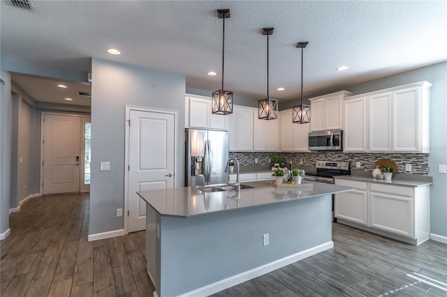 kitchen featuring light hardwood / wood-style flooring, appliances with stainless steel finishes, a kitchen island with sink, sink, and white cabinetry