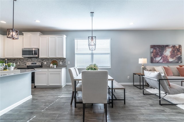 dining space with a textured ceiling, a notable chandelier, and dark hardwood / wood-style floors