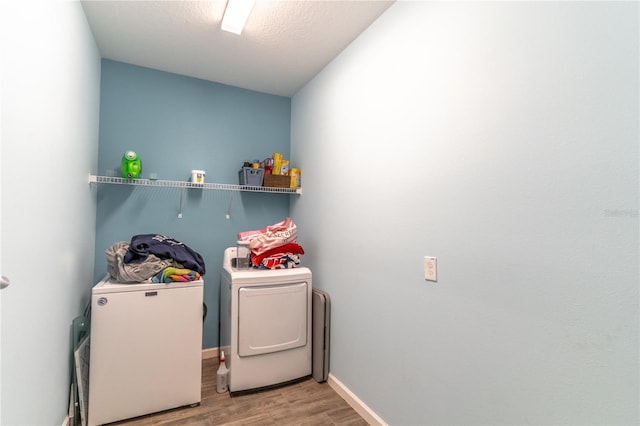 washroom with hardwood / wood-style floors and washing machine and dryer