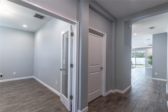 hallway with dark hardwood / wood-style floors and a textured ceiling