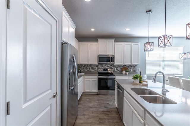 kitchen featuring white cabinets, appliances with stainless steel finishes, sink, and dark wood-type flooring