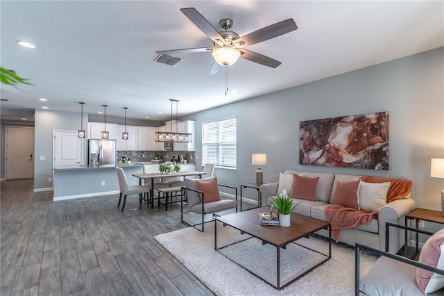 living room with dark wood-type flooring and ceiling fan