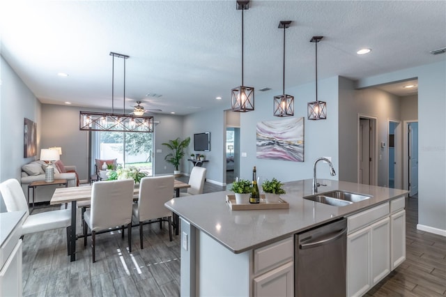 kitchen featuring wood finished floors, a sink, white cabinetry, open floor plan, and dishwasher