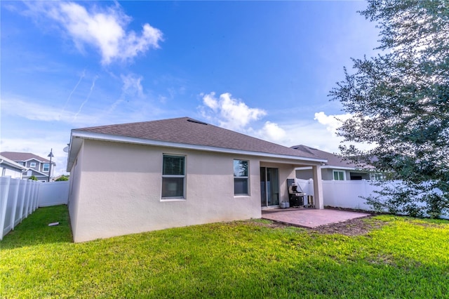 rear view of property featuring a yard and a patio